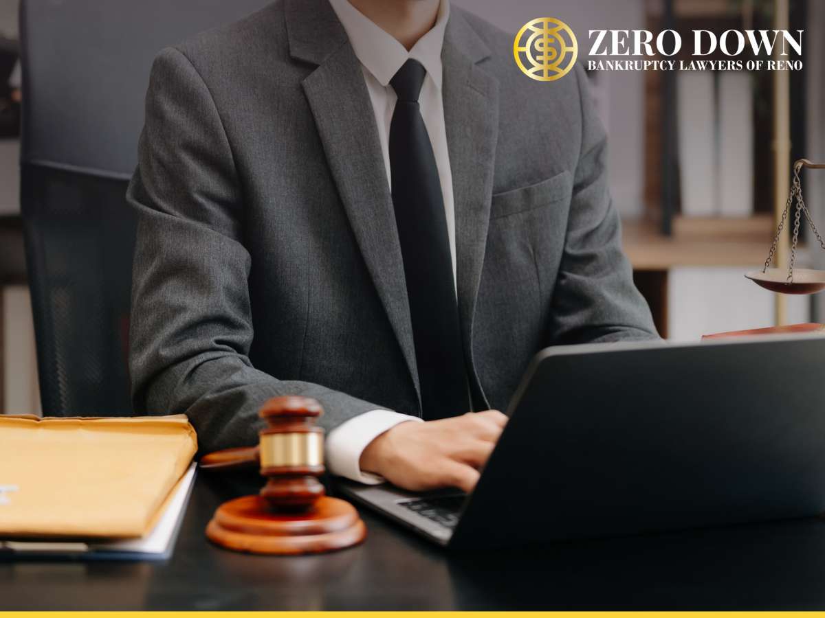 A bankruptcy lawyer in a suit working on a laptop at their desk.